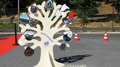 Ein kreativer Baum aus Holz mit bunten Spiegeln zeigt verschiedene Aktivitäten zum Umweltschutz und Klimaschutz.