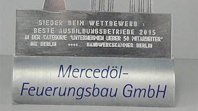 Eine silberne Auszeichnung zeigt den Berliner Fernsehturm und das Brandenburger Tor, gewidmet an Mercedöl-Feuerungsbau GmbH.