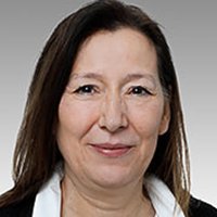 Professionelles Porträt einer selbstbewussten Frau Eine Frau mit langen, dunklen Haaren und einem freundlichen Lächeln, trägt ein weißes Hemd und hat einen neutralen Hintergrund.