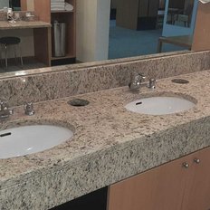 Ein stilvolles Badezimmer mit drei Waschbecken, glänzenden Armaturen und einem hellen, einladenden Ambiente.